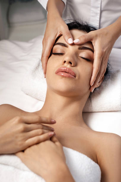anti-aging facial massage. Woman receiving massage from masseur at Spa salon.